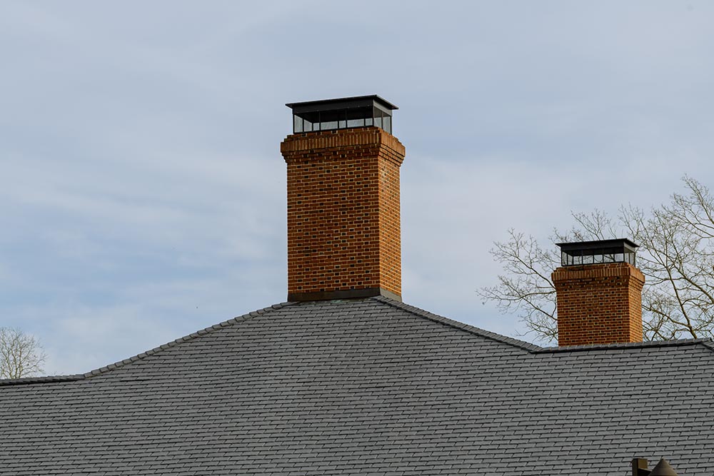 Brick chimney stack on modern contemporary house roof top